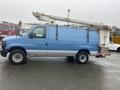 A blue 2009 Ford Econoline van with a white lift apparatus mounted on the top
