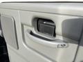 Close-up of the handle and release latch of a gray interior door in a 2013 Ford E-350 Super Duty vehicle