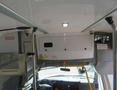 Interior view of a 2020 Chevrolet Express showing the dashboard and overhead storage with an emergency equipment sign visible
