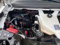 View of the engine compartment of a 2020 Chevrolet Express showing various components including the battery coolant reservoir and electrical wiring