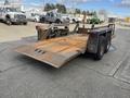 A 2013 JLG Industries Flat Deck Trailer with a rusty metal surface and a lowerable ramp at the rear supported by two wheels