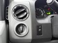 Close-up of the dashboard controls in a 2013 Ford E-350 featuring air vent adjustment and headlight settings with dials and buttons
