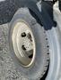 Close-up of a 2019 Hino 195 truck tire showing the wheel rim and tread with some signs of wear and dirt