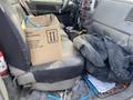 Interior of a 2009 Dodge Ram 5500 showing a cluttered front seat with a cardboard box and various items including cables and a dark tarp on the floor