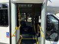 A 2014 Chevrolet Express with an open entry door revealing a wheelchair accessibility feature and two seats inside