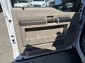 The image shows the interior door panel of a 2008 Ford F-550 featuring a beige finish with a handle and storage compartment
