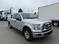 2015 Ford F-150 in silver with a crew cab design featuring chrome accents and a front grille with the Ford logo