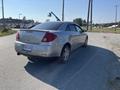 A 2006 Pontiac G6 in silver color parked on a road with a sleek design and tinted windows