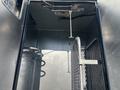 Interior view of a 2008 International 4400 truck cab showing a metal partition a spring mechanism and metal hoses attached to the walls