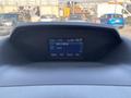 A 2016 Ford Transit 150 dashboard displaying a radio interface with station information and time