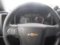 Steering wheel of a 2015 Chevrolet Silverado 1500 with Chevrolet logo and instrument cluster displaying speed and fuel gauges