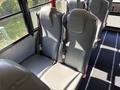 Interior view of a 2013 International CE300 school bus with gray vinyl seats visible in the foreground and seatbelts attached
