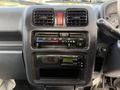 The dashboard of a 2008 Suzuki Carry featuring climate control knobs a radio display and an air conditioning button