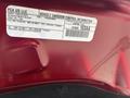 A 2015 Jeep Grand Cherokee with an emission control information label attached under the hood