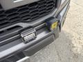 A close-up of a 2019 Ford F-150's front grille featuring two auxiliary lights mounted on the bumper