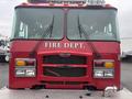 A 2006 E-One fire truck with a red exterior features the words FIRE DEPT prominently displayed on the front grille and multiple lights above the windshield