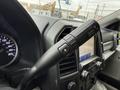 Close-up of a 2020 Ford F-550 gear shift lever with drive mode buttons and an odometer gauge visible in the background