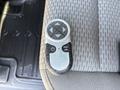 A remote control with a circular button layout including directional arrows and additional buttons placed on a textured fabric surface
