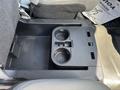 A center console in a 2019 Ford F-150 with two cup holders and a storage compartment
