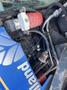 Close-up of the engine components of a 2010 New Holland T4050 with visible hoses and a red fuel filter along with various connectors and mechanical parts