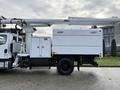 2015 Freightliner M2 bucket truck featuring a raised boom equipped with a work platform and storage compartments on the side