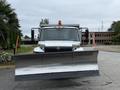 A 2012 International TerraStar front-end snow plow truck with an extended metal blade and an orange hazard light on top