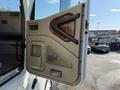 The door of a 2007 International 9200i truck with a sleek design featuring a wood panel and a handle for easy access