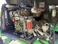 A close-up of a 2015 JLG 450AJ aerial lift's engine compartment featuring various mechanical components and hoses