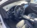 Interior view of a 2014 Mercedes-Benz CLA-Class showing the steering wheel dashboard and control panel with leather seats