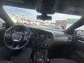 Interior view of a 2015 Dodge Charger showing the steering wheel dashboard and controls with a partially visible driver's seat
