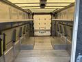 Interior of a 2012 Ford E-450 Super Duty showing a spacious cargo area with metal walls and built-in shelves along the sides