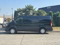 A dark green 2016 Ford Transit 150 van parked with side view showing its elongated body and white wheels