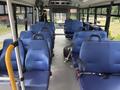 Interior of a 2020 Chevrolet Express bus featuring blue upholstered seats arranged in rows with seatbelts and a central aisle