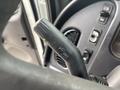A close-up view of the gear shift lever in a 2006 Freightliner M2 106 featuring markings for various functions and controls