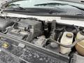 The engine compartment of a 2024 Ford E-450 featuring various components including the air filter battery and fluid reservoirs