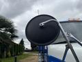 A side mirror of a 2013 International DuraStar 4300 truck with a black round mirror surface and a chrome arm