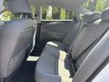 The interior of a 2014 Hyundai Sonata showing the backseat with gray fabric upholstery and seat belts