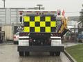 A 2016 Freightliner 108SD truck with a rear view featuring bright yellow and black reflective checkerboard patterns and an attached work arm on one side