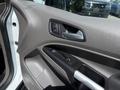 The interior door panel of a 2021 Ford Transit Connect featuring a control panel with buttons for window functions and a handle
