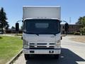 A white 2012 Isuzu NPR HD box truck viewed from the front with a prominent grille and large side mirrors