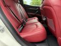 Interior view of the back seats of a 2016 Maserati Ghibli featuring red leather upholstery and seat belts
