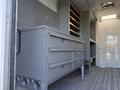 Interior of a 2012 Ford Econoline E-450 featuring gray cabinets and drawers arranged for storage with a streamlined design