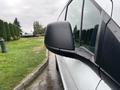 A close-up view of the side mirror of a 2019 Ford Transit Connect with raindrops on it