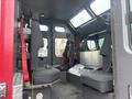Interior of a 2006 E-One Typhoon fire truck showing seats with seatbelts and a metal dashboard area