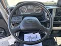The interior of a 2020 Hino 338 featuring a steering wheel with controls and a dashboard displaying gauges and indicators