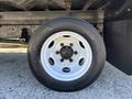 Close-up of a white wheel and tire mounted on a 2022 Isuzu NRR showing the tire tread and wheel design