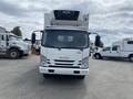 A 2019 Isuzu NRR truck with a refrigerated unit on top facing directly toward the viewer with clear headlights and a white exterior