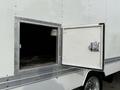 A 2012 Ford F-550 truck with a closed door on the side and an open compartment revealing a dark interior