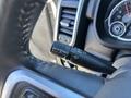 Close-up of a RAM truck's windshield wiper control stalk and dashboard featuring a speedometer and other gauges