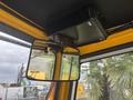 Interior view of a 2004 Bombardier SW48 showing a rearview mirror attached to the ceiling with a black electronic device positioned above it
